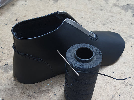 Artisan stitching leather shoes by hand